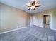 Spacious main bedroom features neutral walls, plush carpet, and a ceiling fan at 1000 E Woodlawn Rd # 402, Charlotte, NC 28209