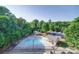 Aerial view of a community pool with lots of trees and parking at 1000 E Woodlawn Rd # 402, Charlotte, NC 28209