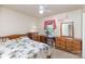 Bright bedroom with a ceiling fan, wood furniture, and a cozy bed with a palm tree-themed comforter at 1009 N Main St, Mount Holly, NC 28120