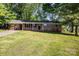 Charming, single-story brick home with a well-manicured lawn and mature trees, creating a welcoming curb appeal at 1141 Carolina Cir, Statesville, NC 28677