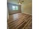 Comfortable bedroom featuring hardwood floors, a ceiling fan, and a large window at 117 Woodland Ave, Shelby, NC 28152