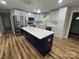 Updated kitchen with stainless steel appliances, island with white countertop and stylish pendant lighting at 117 Woodland Ave, Shelby, NC 28152