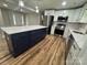 Updated kitchen showcasing a dark island with marble top, stainless steel appliances and wood-style flooring at 117 Woodland Ave, Shelby, NC 28152