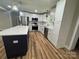 Bright kitchen featuring white cabinets, stainless steel appliances, an island with marble countertop and wood-style flooring at 117 Woodland Ave, Shelby, NC 28152