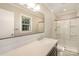 Bright bathroom with a vanity, frameless mirror, glass shower, and plenty of natural light at 118 Spicewood Cir, Troutman, NC 28166