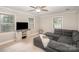 Cozy living room with hardwood floors, a grey sectional, and plenty of natural light from three windows at 118 Spicewood Cir, Troutman, NC 28166
