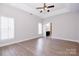 Spacious bedroom featuring tray ceiling, wood floors and large windows with modern white shutters at 1365 Winged Foot Dr, Denver, NC 28037