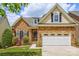 Charming stone-clad home with a two-car garage, manicured lawn, and lovely landscaping details at 1365 Winged Foot Dr, Denver, NC 28037