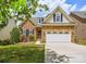 Charming two-story home with a stone facade, manicured lawn, and a two car garage at 1365 Winged Foot Dr, Denver, NC 28037