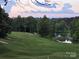 Scenic view of a lush green golf course with a pond and fountain surrounded by mature trees at 1365 Winged Foot Dr, Denver, NC 28037