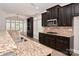 Eat-in kitchen offers bar seating, granite countertops and dark wood cabinetry at 1365 Winged Foot Dr, Denver, NC 28037