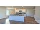 Bright kitchen boasts white cabinets, a granite countertop island, stainless steel appliances, and wood-look floors at 14026 Wilson Mac Ln, Charlotte, NC 28278