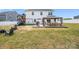 Expansive backyard featuring a covered patio, playset, grill, grassy area, and white fence at 1636 Tundra Ln, Denver, NC 28037