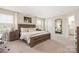 Well-lit bedroom with a large bed, wooden furniture, soft carpet, and a view into an ensuite bathroom at 1636 Tundra Ln, Denver, NC 28037