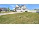 Expansive lawn featuring an attached three-car garage, long driveway, and fenced backyard in a residential neighborhood at 1636 Tundra Ln, Denver, NC 28037