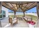 Beautiful outdoor living space with a covered patio, ample seating, and a well-maintained lawn and white fencing at 1636 Tundra Ln, Denver, NC 28037