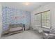 Charming Bedroom featuring a patterned accent wall, a rocking chair, crib and a window with natural light at 1655 Buckland Ct, Indian Land, SC 29707