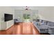 Bright living room with hardwood floors, gray sofa, large TV, and sliding door access to the outside at 1655 Buckland Ct, Indian Land, SC 29707