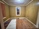 Bedroom with wood paneling, hardwood floors and single window waiting to be personalized at 1703 Lowder St, Albemarle, NC 28001