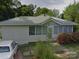 Cozy one-story home with light siding, lush landscaping, and a metal roof at 1703 Lowder St, Albemarle, NC 28001