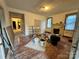 Living room featuring hardwood floors, a fireplace, and windows, in need of some TLC at 1703 Lowder St, Albemarle, NC 28001