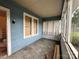 Enclosed front porch with wood plank siding, large windows, and a concrete floor at 1703 Lowder St, Albemarle, NC 28001