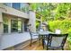 This view showcases a back patio with chairs and table surrounded by lush green trees at 173 Greenridge Rd, Lake Wylie, SC 29710