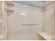 Shower with tiled walls, corner shelves, a grab bar, and a built-in seat for convenience at 173 Greenridge Rd, Lake Wylie, SC 29710