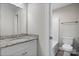Bathroom with granite countertops, white cabinets, and a tub and toilet in the adjacent room at 1735 15Th Street Ne Pl, Hickory, NC 28601