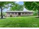 Charming single-story brick home with a lush green lawn and mature trees creating a welcoming curb appeal at 174 Wintergreen Cir, Statesville, NC 28677