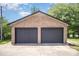 Two car detached brick garage with dark gray doors and a concrete pad at 174 Wintergreen Cir, Statesville, NC 28677