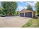 A two car detached brick garage with dark gray doors and a large concrete parking pad at 174 Wintergreen Cir, Statesville, NC 28677
