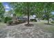 Spacious backyard featuring a patio, outdoor fireplace, and mature trees for privacy at 2218 Legacy Oak Dr, Waxhaw, NC 28173