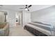 Well-lit bedroom featuring a ceiling fan and plush carpet floors. View into another bedroom at 2218 Legacy Oak Dr, Waxhaw, NC 28173