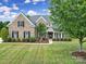 Traditional brick home with black shutters, green lawn, and covered front porch at 2218 Legacy Oak Dr, Waxhaw, NC 28173