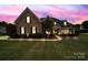 Charming brick home with manicured lawn and well-lit exterior at dusk at 2218 Legacy Oak Dr, Waxhaw, NC 28173