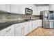 Modern kitchen with stainless steel appliances, granite countertops, white cabinetry, and stylish backsplash at 2218 Legacy Oak Dr, Waxhaw, NC 28173