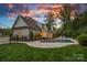 Backyard view of an in-ground pool and patio with a white brick home and fence under a twilight sky at 2309 Ethan Way, Weddington, NC 28104