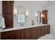 Elegant bathroom featuring double vanity with marble countertop, designer mirrors, and dark wood cabinetry at 2309 Ethan Way, Weddington, NC 28104
