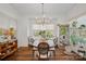 Sunlit dining area with hardwood floors, a chandelier, and large windows overlooking the outdoors at 2309 Ethan Way, Weddington, NC 28104