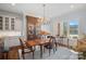 Sunlit dining room with a classic chandelier, hardwood floors, and a large window overlooking the yard at 2309 Ethan Way, Weddington, NC 28104