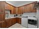 Well-appointed laundry room with custom wood cabinetry, tile backsplash, and modern washer and dryer at 2309 Ethan Way, Weddington, NC 28104