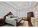 Comfortable bedroom featuring tray ceiling, chandelier, large windows, and hardwood flooring at 2309 Ethan Way, Weddington, NC 28104