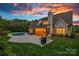 Rear exterior of a white brick home with a patio, in-ground pool, grill, and furniture, with a twilight sky at 2309 Ethan Way, Weddington, NC 28104