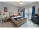Bedroom featuring wood bed frame, ceiling fan, and a window with blue curtains at 2489 Highway 161 S Hwy, York, SC 29745