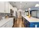 Updated kitchen features stainless steel appliances, white cabinets, blue island, hardwood flooring, and pendant lighting at 2489 Highway 161 S Hwy, York, SC 29745