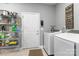 Functional laundry room with modern washer and dryer, storage shelving, and backyard access at 2489 Highway 161 S Hwy, York, SC 29745