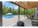 View of backyard pool and covered outdoor living area with grill, dining table, and seating at 2489 Highway 161 S Hwy, York, SC 29745