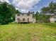 Expansive backyard with a deck, lawn, and the rear exterior of the home on a sunny day at 2544 Cedarwild Rd, Charlotte, NC 28212