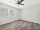 This bedroom features a ceiling fan, large windows, and vinyl wood flooring at 2544 Cedarwild Rd, Charlotte, NC 28212